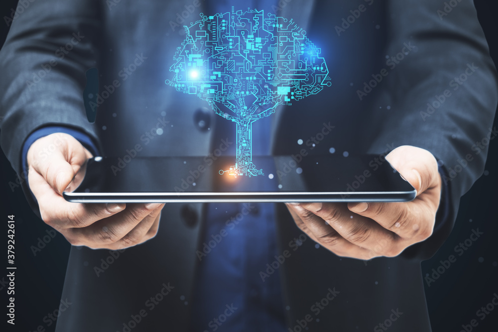 Businessman holding digital tablet with circuit tree hologram.