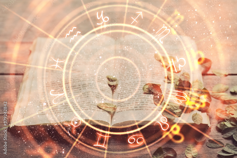 Book and abstract orange zodiac wheel backdrop.