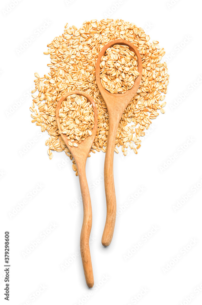 Spoons with raw oatmeal on white background