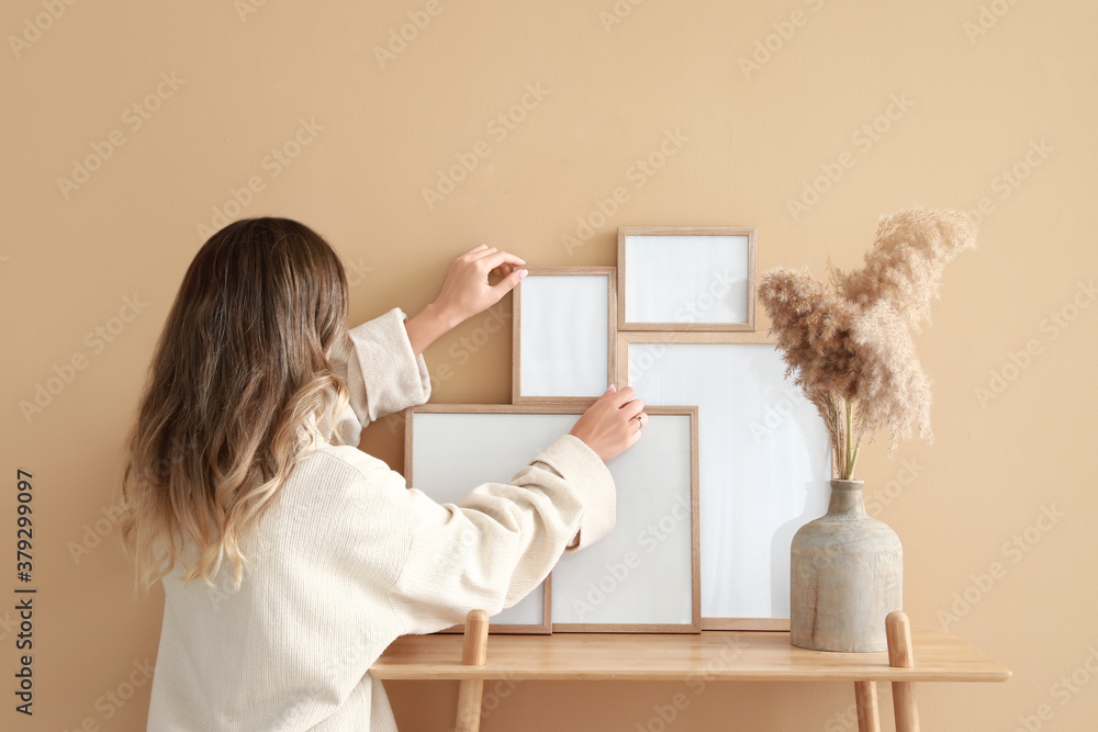 Woman decorating room with photo frames