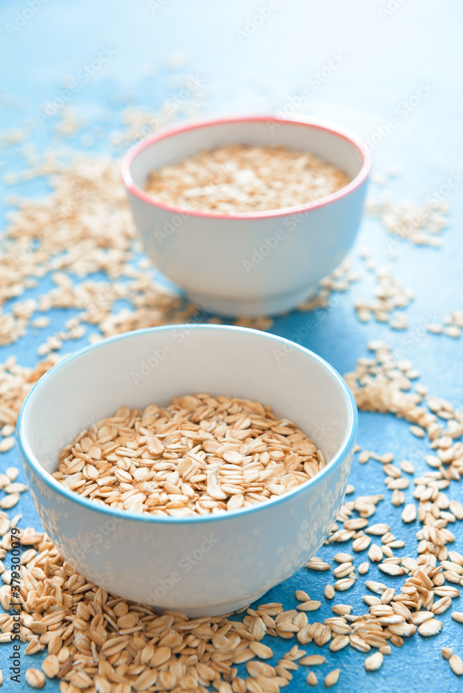 Bowls with raw oatmeal on table