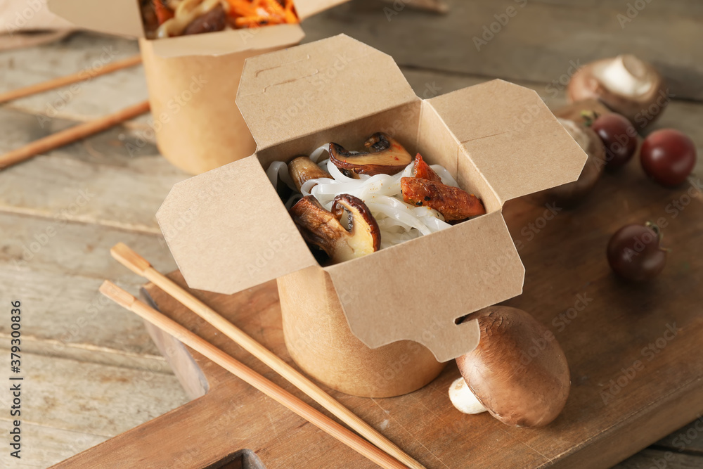 Box with tasty rice noodles on table