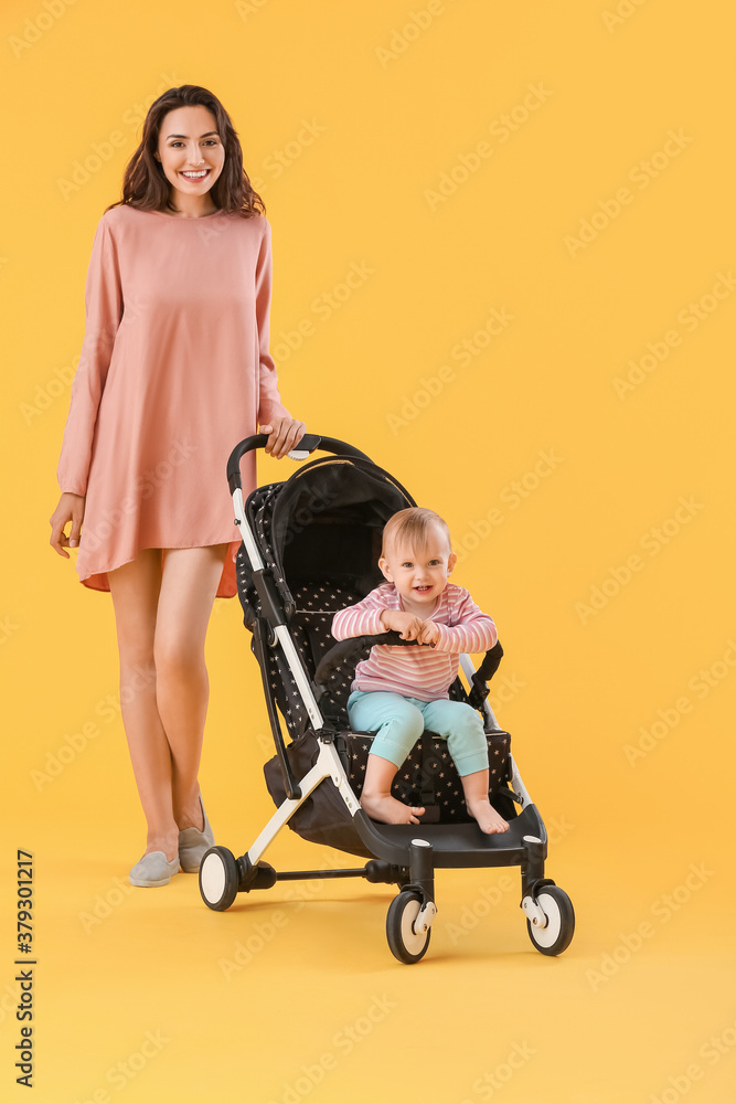 Woman and her cute baby in stroller on color background