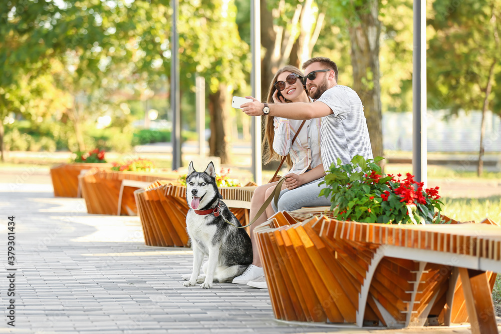 Young couple with cute Husky dog in park