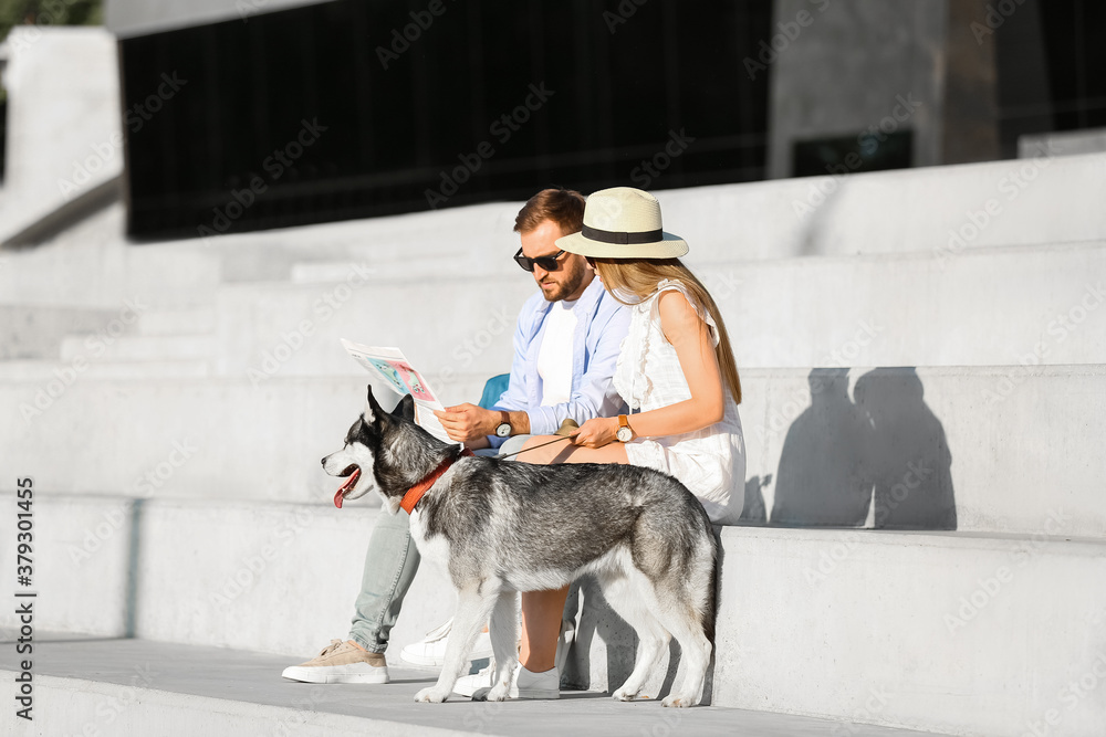 Young couple with cute Husky dog outdoors