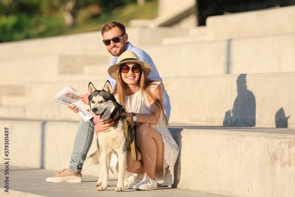 Young couple with cute Husky dog outdoors