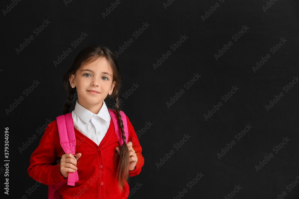 Little schoolgirl on dark background