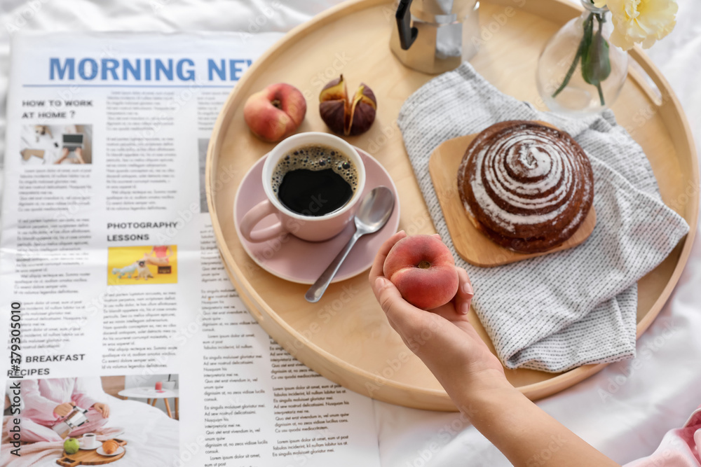 Young woman having tasty breakfast in bed