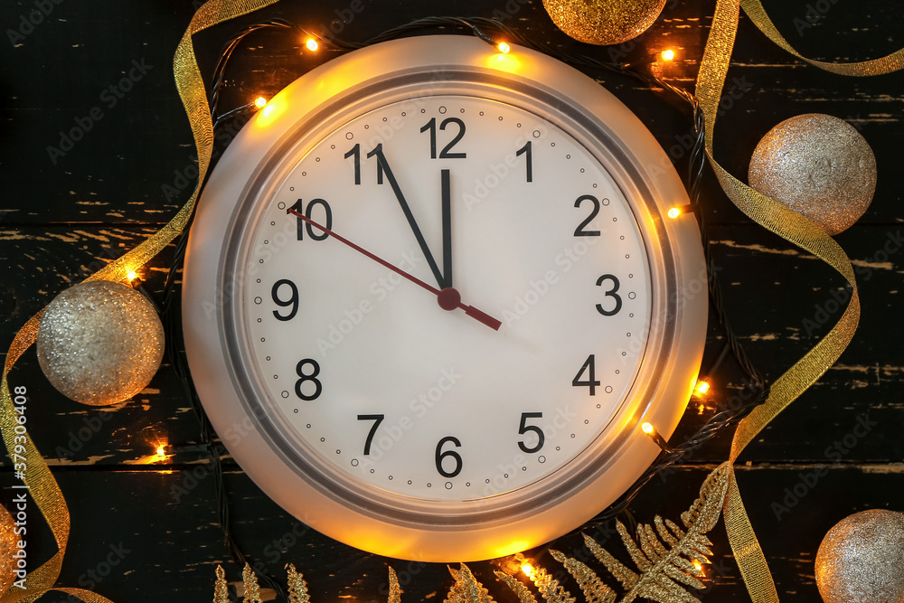 Clock, decor and Christmas lights on dark background