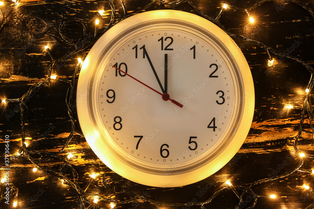 Clock and Christmas lights on dark background