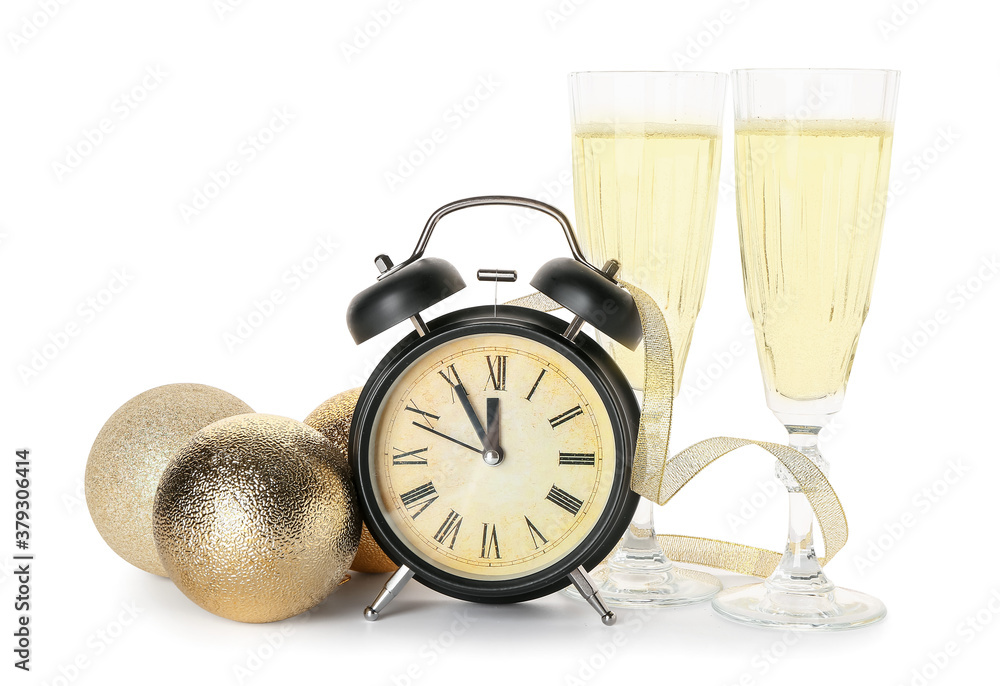 Alarm clock, decor and glasses of champagne on white background. New Year time