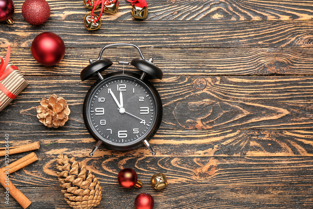 Composition with alarm clock and Christmas decor on wooden background