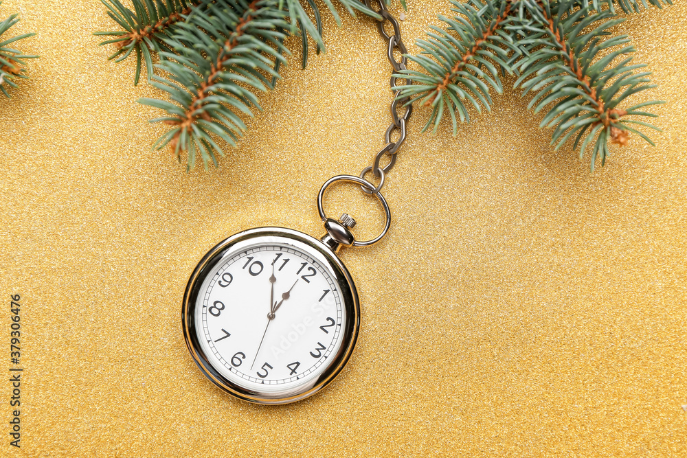 Pocket watch and fir branches on color background. New Year time