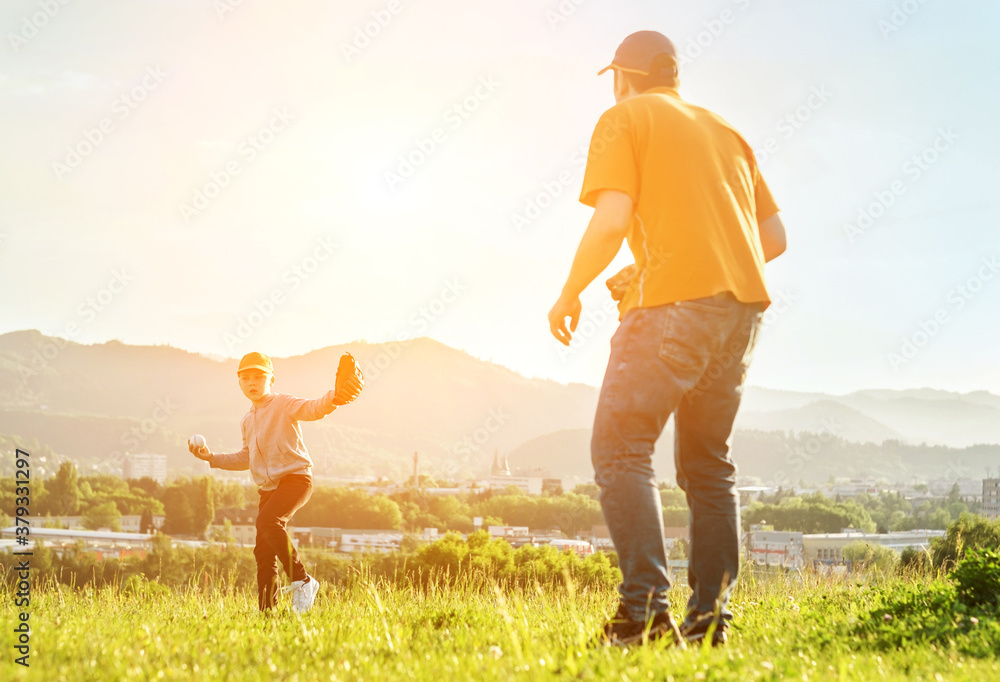 Father and son playing in baseball. Playful Man teaching Boy baseballs exercise outdoors in sunny da