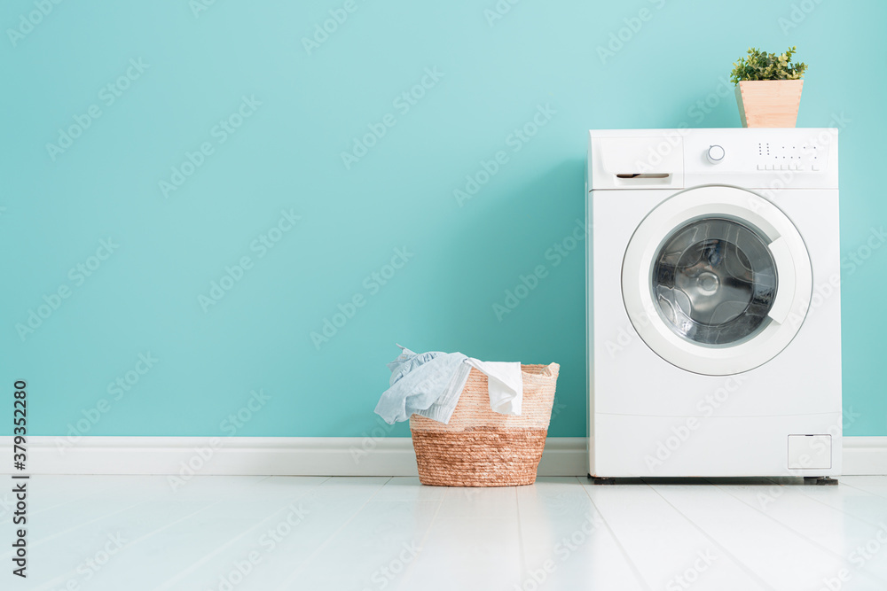 washing machine on teal wall background