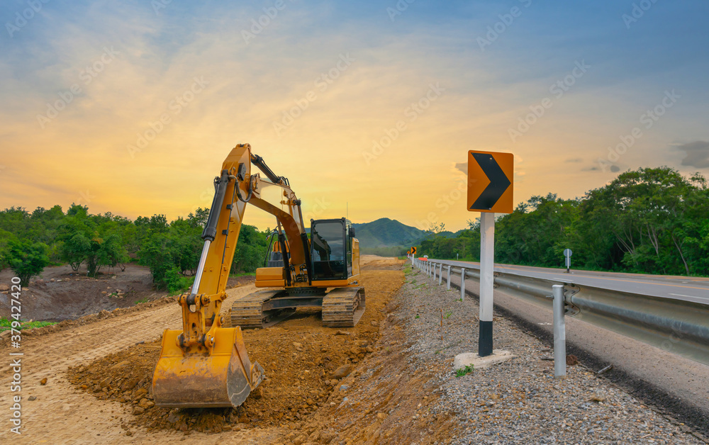 反铲正在处理道路施工现场的石头堆