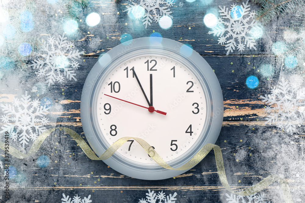 Clock and snowflakes on dark wooden background. Christmas time