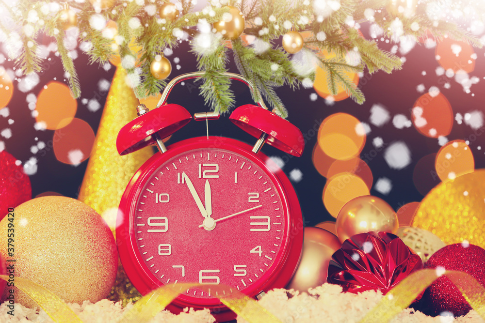 Alarm clock, snow and Christmas decor against blurred lights