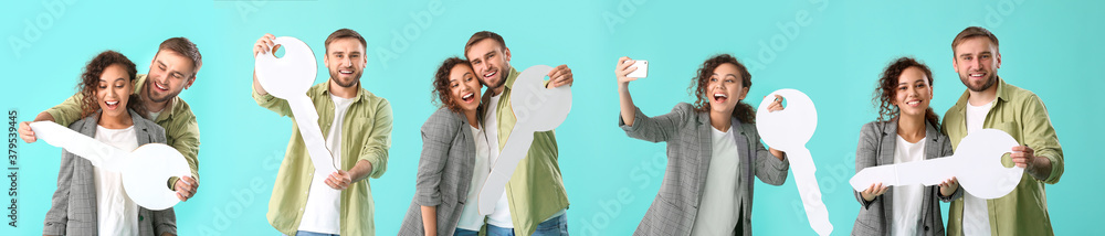 Happy young couple with big paper key on color background