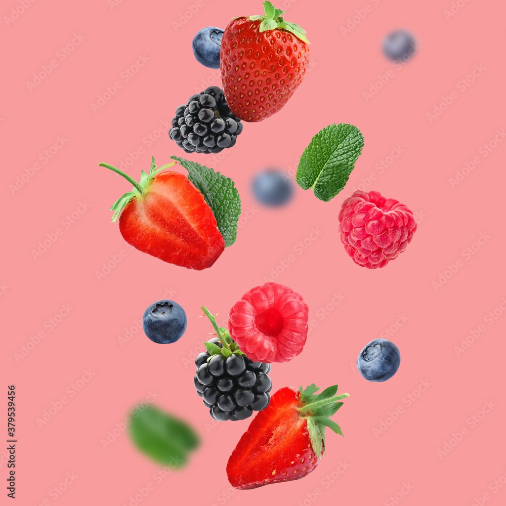 Falling different tasty berries on color background