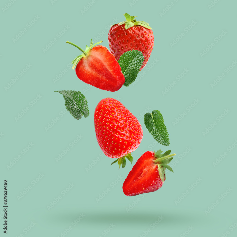 Falling tasty strawberries on color background