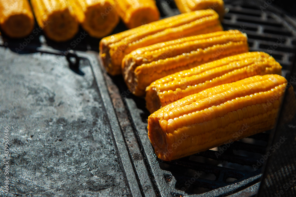 A professional cook prepares corn on the grill outdoor, food or catering concept