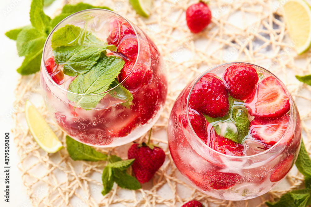 Glasses of fresh strawberry mojito on table