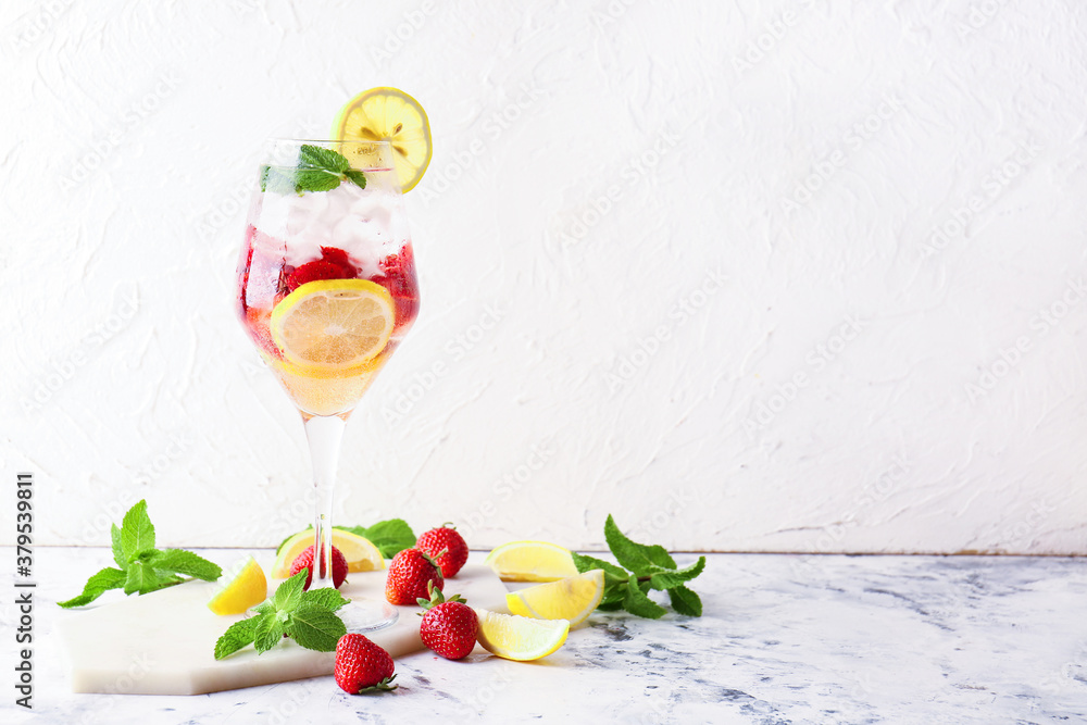 Glass of fresh strawberry mojito on light background