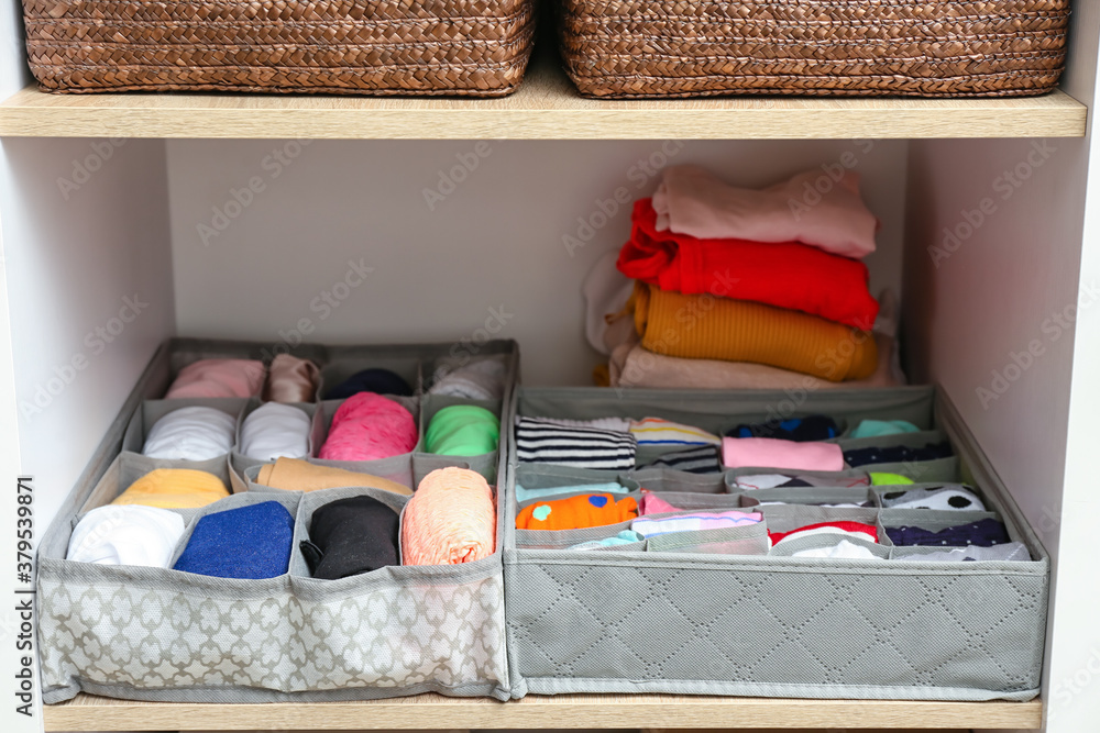 Organizers with clean clothes in closet