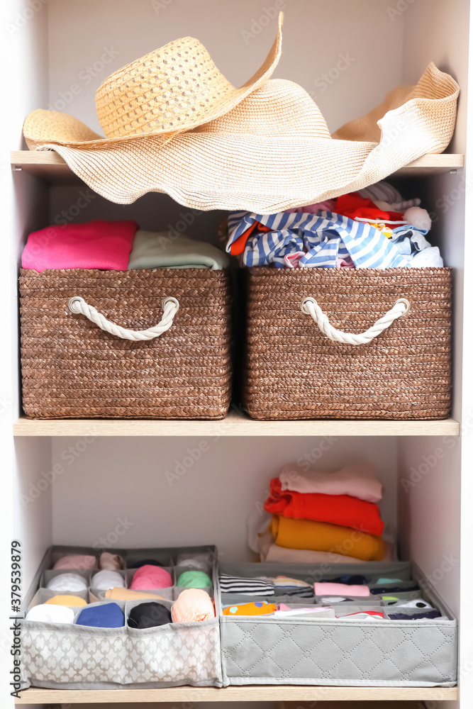 Organizers with clean clothes in closet