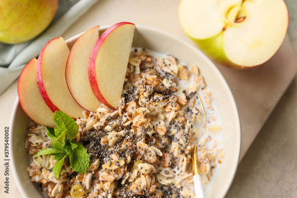 Bowl with tasty sweet oatmeal on table, closeup