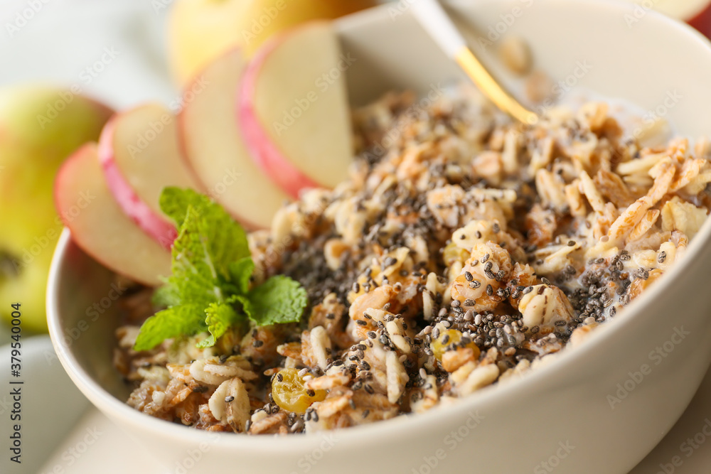 Bowl with tasty sweet oatmeal on table, closeup