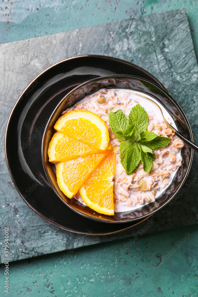 Bowl with tasty sweet oatmeal on color background