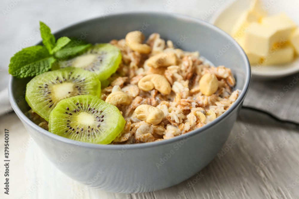 Bowl with tasty sweet oatmeal on table