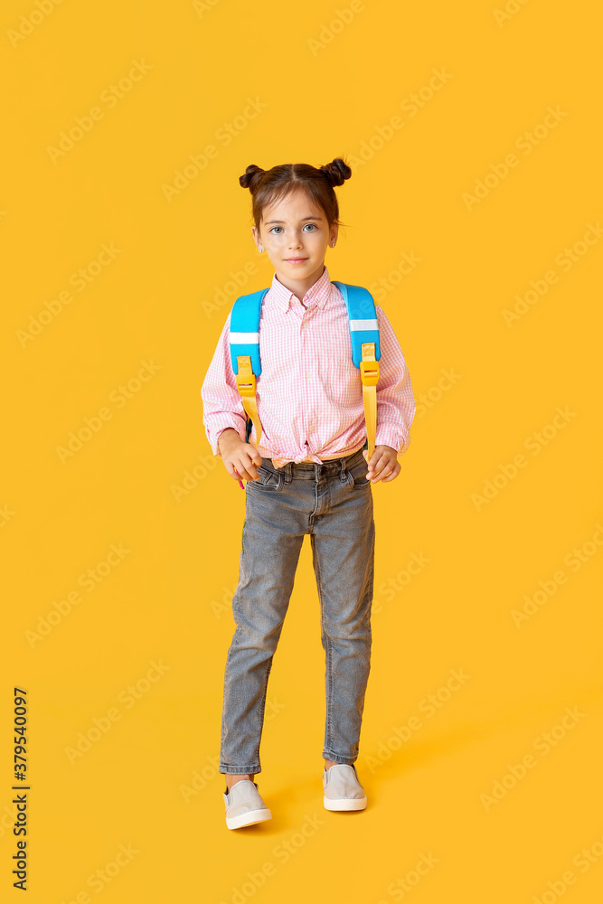 Little schoolgirl on color background