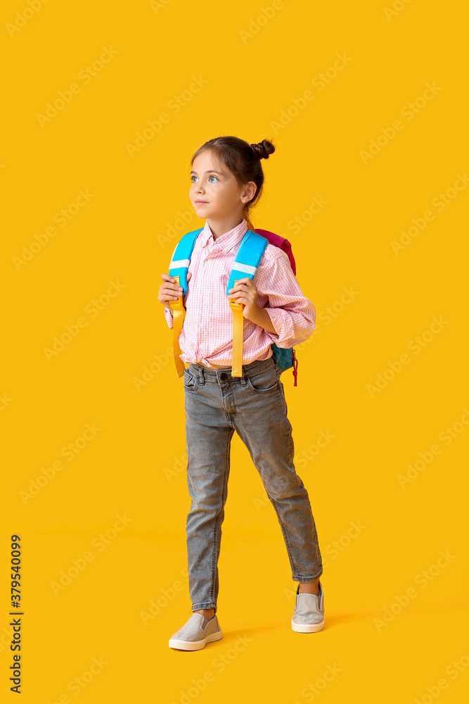 Little schoolgirl on color background