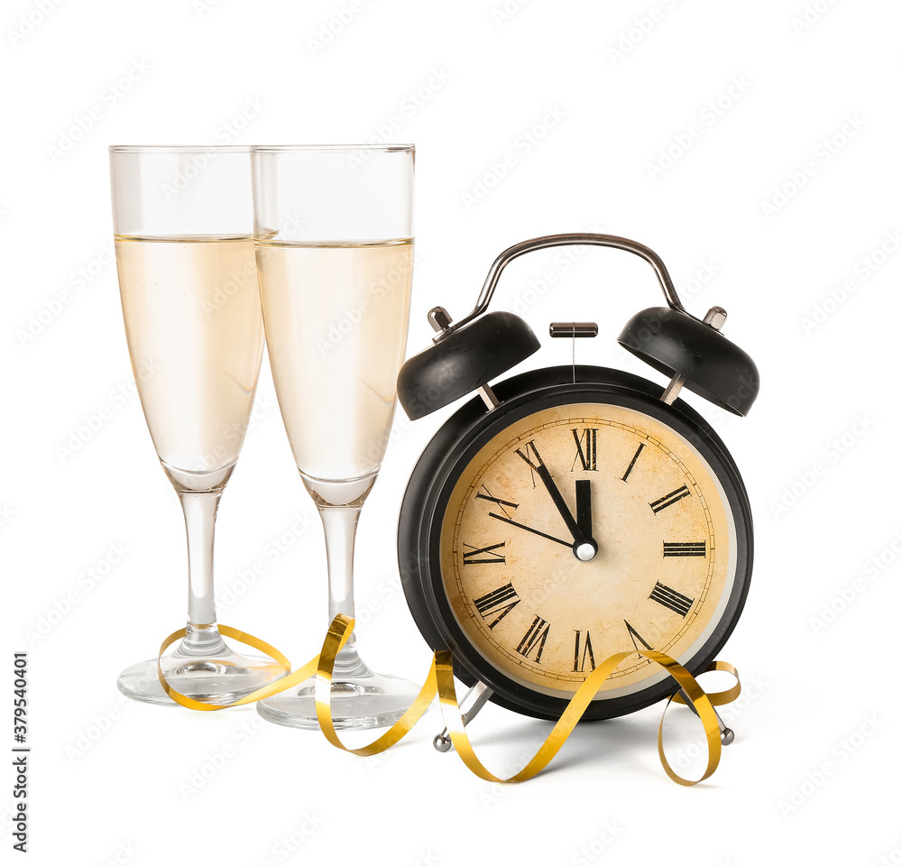 Alarm clock and glasses of champagne on white background. Christmas time