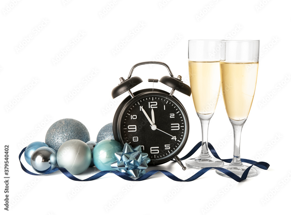 Alarm clock, Christmas decor and glasses of champagne on white background