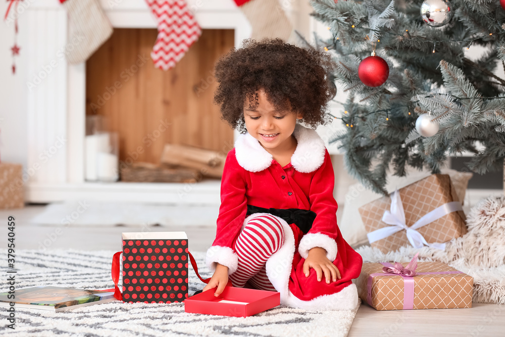 Cute African-American girl with Christmas gifts at home