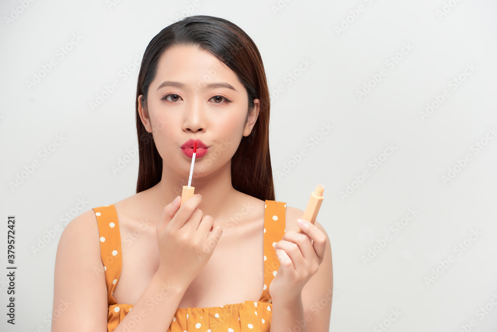 Attractive and beautiful Asian girl paint lips a beige lipstick