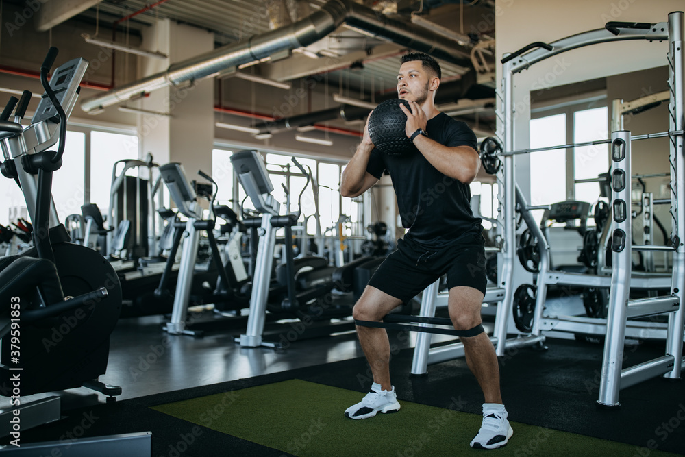 Man holding ball and doing squats.