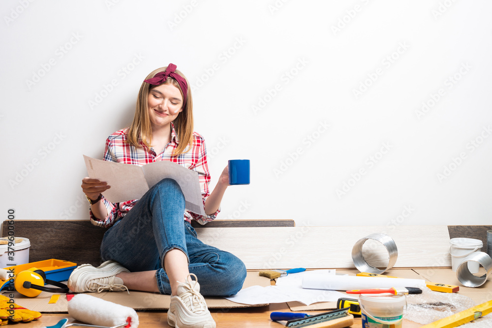 Beautiful girl sitting with paper blueprint