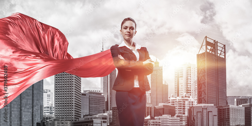 Concept of power and sucess with businesswoman superhero in big city