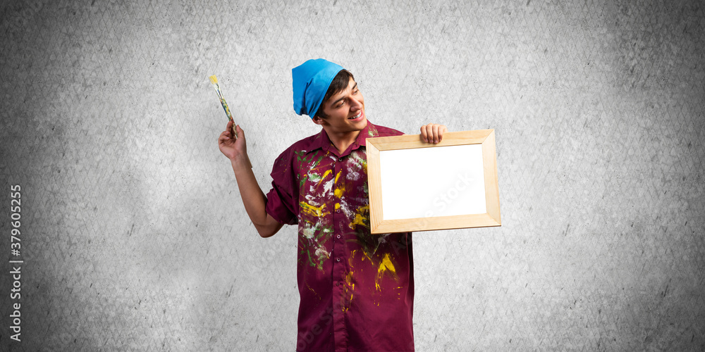 Young handsome painter artist holding paintbrush