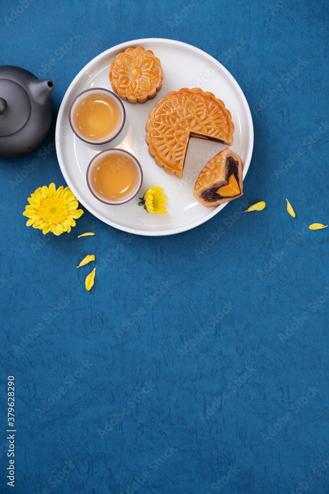 Moon cake for Mid-Autumn Festival, delicious beautiful fresh mooncake on a plate over blue backgroun