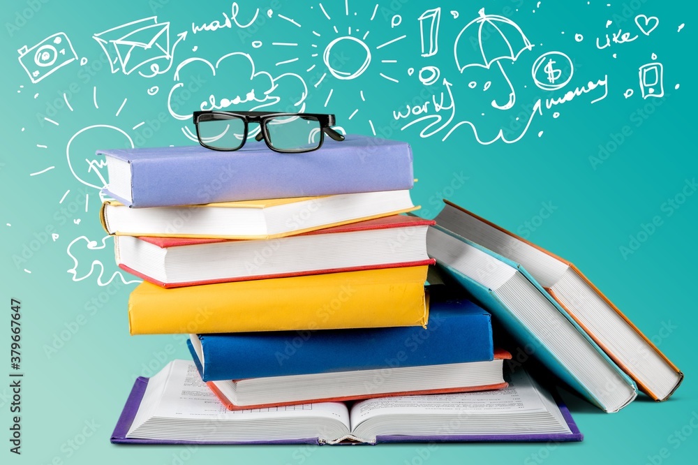 Stack of books with reading glasses on table