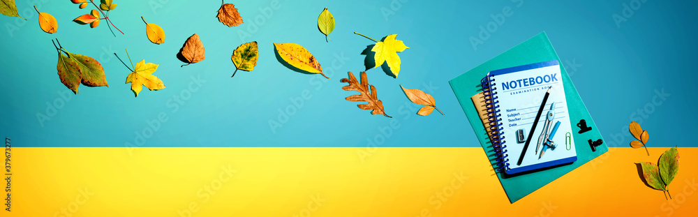 Notebooks with school supplies and autumn leaves - flat lay