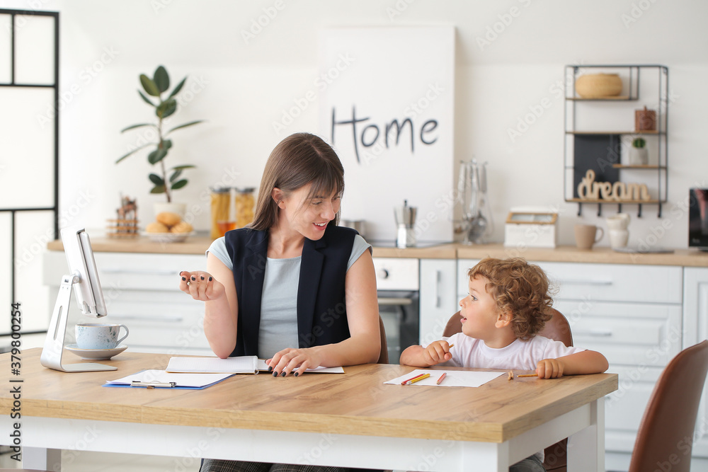 Working mother with little son in kitchen at home