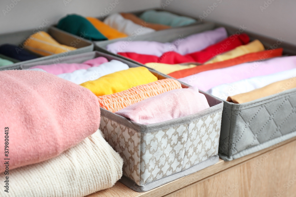 Organizers with clean clothes in closet