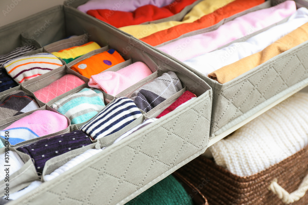 Organizers with clean clothes in closet